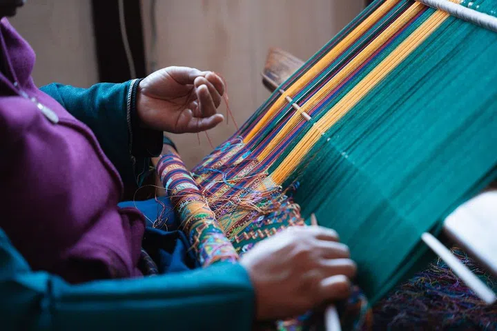 At Gagyel Lhundrup Weaving Centre in Thimpu, guests can watch natural fibres like cotton and silk woven into intricately patterned textiles on hand looms. (Photo: Josh van der Ploeg)