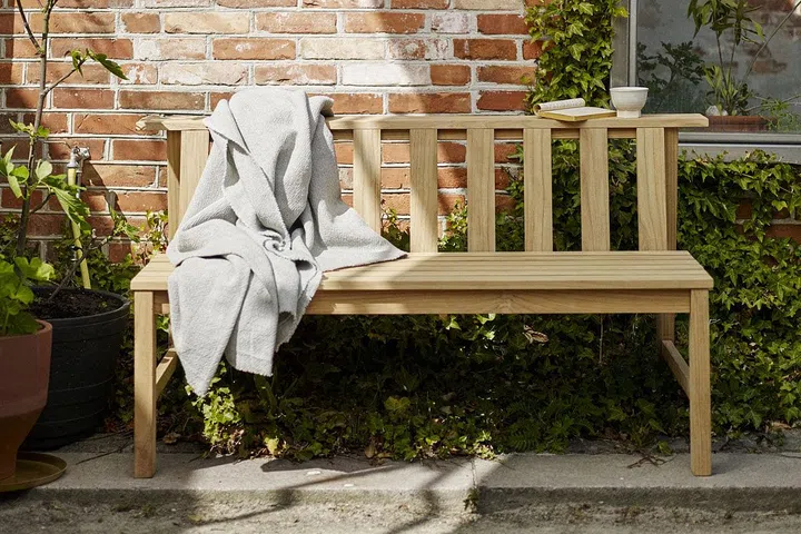 The two horizontal planks that form the Plank bench’s backrest can be used as a shelf for flower pots or a lantern at night to create the perfect ambience. (Photo: Fritz Hansen)