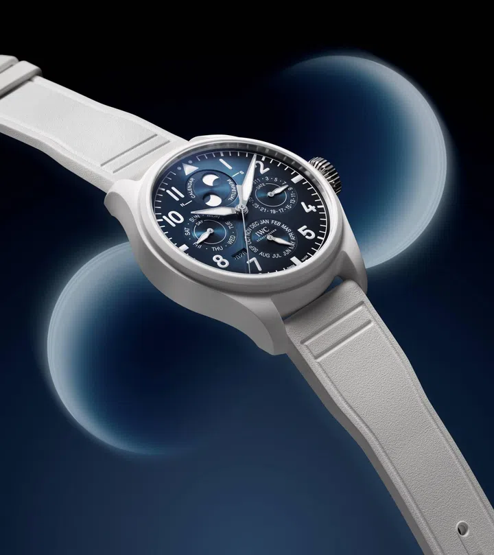 IWC Big Pilot’s Watch Perpetual Calendar ProSet Le Petit Prince in white ceramic, featuring a deep blue gradient dial with perpetual calendar displays, double moon-phase indication and a white rubber strap.