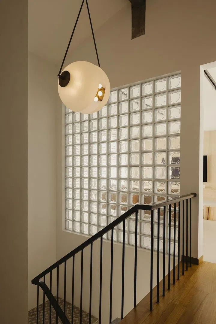 The stairwell contains a lot of atmosphere in terms of texture and spatial quality. Surrounding breezeblocks were replaced with glass blocks that brighten this space while helping with the modern comforts of air-conditioning. (Photo: Studio Periphery)