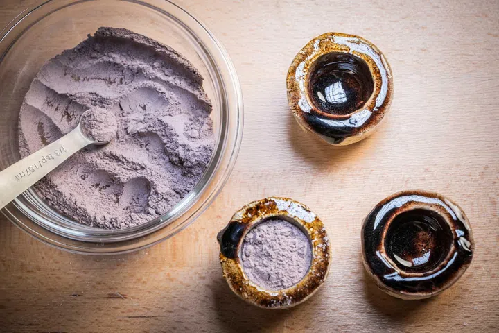 Selection of coloured enamel powders used in the creation of the Van Cleef & Arpels Midnight Heure d’Ici & Heure d’ailleurs watch, showcasing the carefully blended pigments developed to achieve the dial’s rich amber hue inspired by the changing glow of rubies.