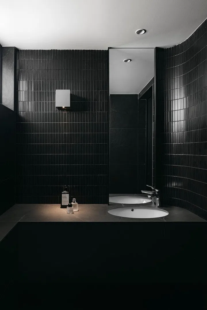 A design hack when using dark colour schemes: Layer the textures to maintain visual interest. In the master bathroom, gloss finish “kit kat” tiles offset the vanity counter. (Photo: Studio Periphery)