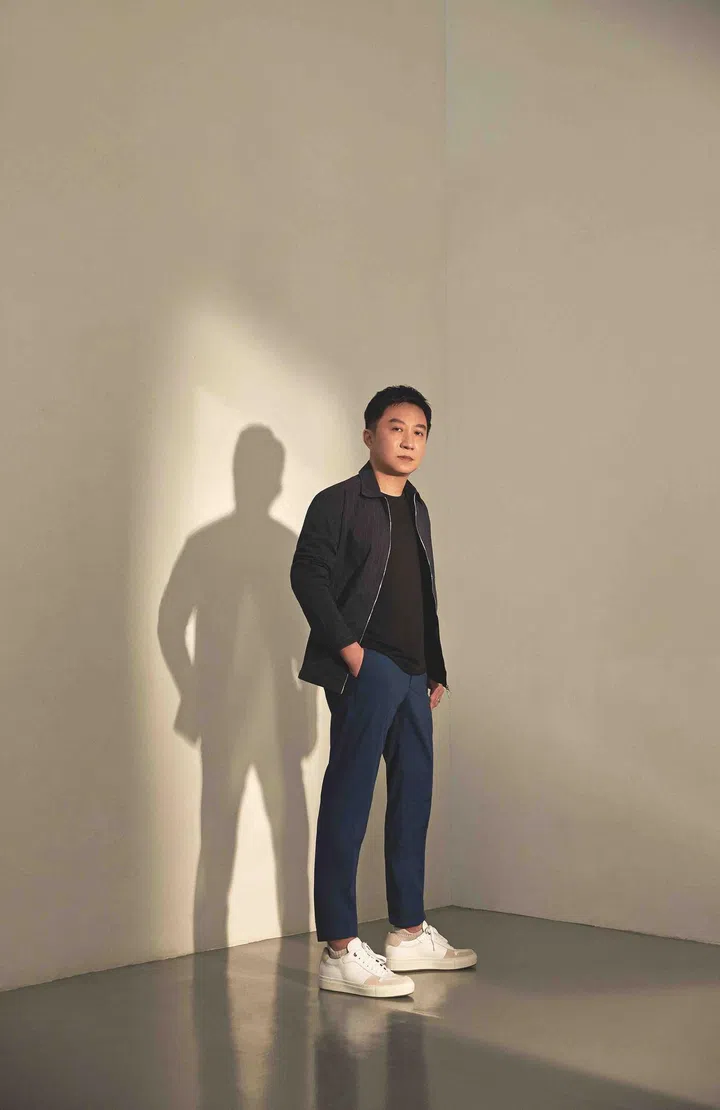 Zou is wearing a polycotton striped blouson and cotton chinos from Dunhill, and sneakers from Boss.