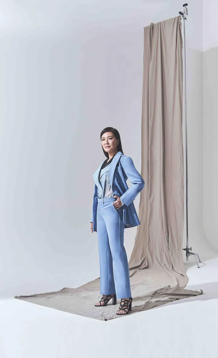 Michelle Lau is wearing a printed organza blouse from Giorgio Armani, a wool jacket with matching pants from Etro, a beaded necklace from Emporio Armani, and leather cutout heels from Hermes.