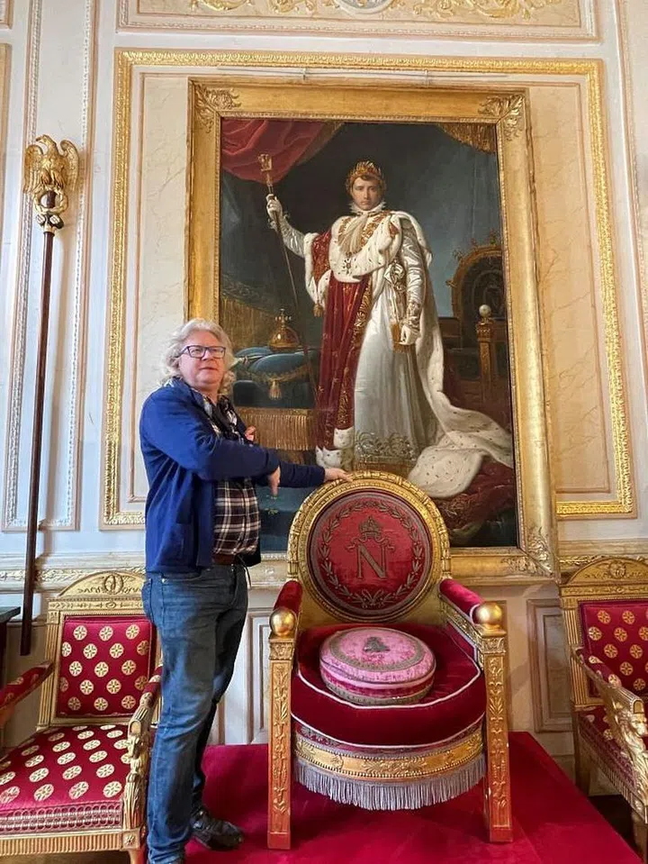 Pierre-Jean with Napoleon's original throne beneath a painting of him in the throne room of Tuileries Palace. Photo: ArtLuxury Experience, Grace Ma