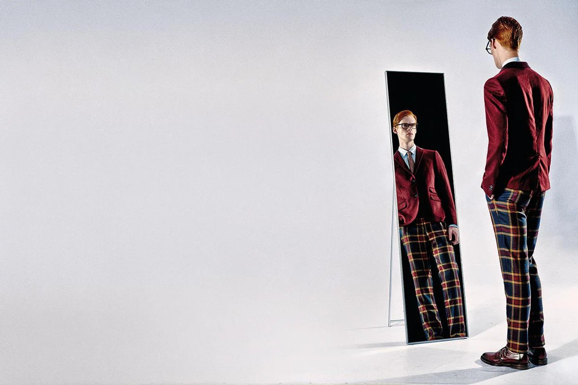 Balance out patterned trousers with solid-colour elements.

Maroon wool blazer, white cotton shirt, wool pants & grey wool tie from Gucci. Glasses from Ray-Ban.
