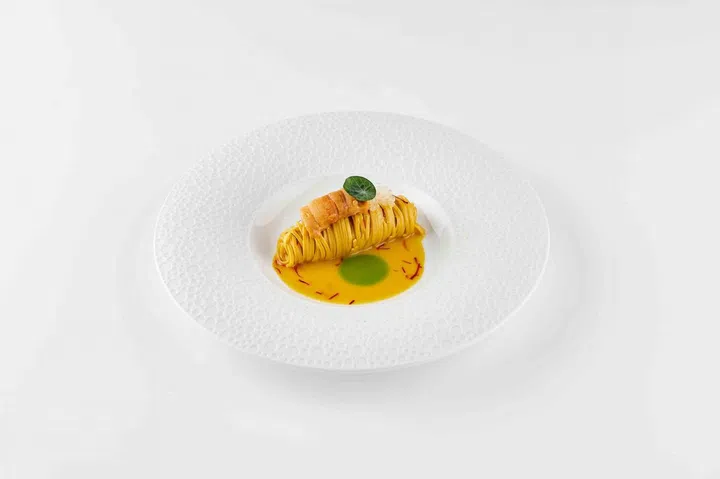 'Oro Colato': 32 egg yolk taglierini, saffron dell’aquila, reganisso, cedro pearls, sea urchin. Photo: Art/il Lido Group
