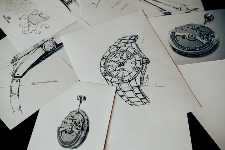 Design sketches of the Grand Seiko Spring Drive U.F.A. Ushio 300 Diver displayed beside photographs of the Calibre 9RB1 Spring Drive movement, highlighting the watch’s development process, engineering refinements and the movement that delivers an annual accuracy of ±20 seconds.