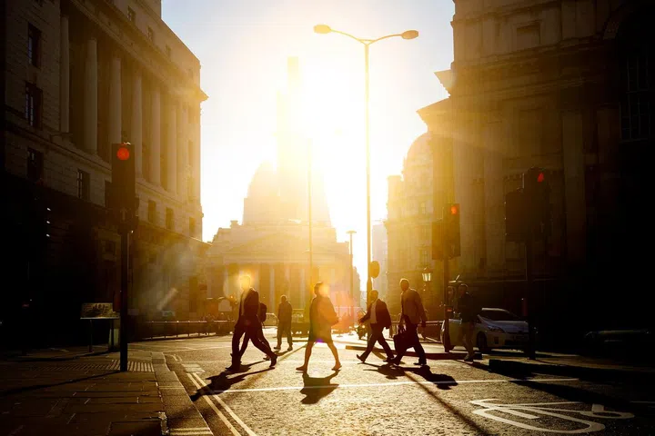 People walking to work as the sun rises. Photo credit: Getty Images
