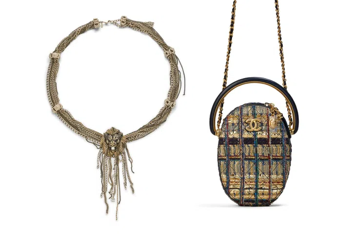 A Chanel oval gold tweed handbag inspired by the sacred scarab beetle displayed alongside a gold-toned lion chain belt embellished with faux pearls, both from Karl Lagerfeld’s Egyptian-inspired Pre-Fall 2019 Métiers d’Art collection.