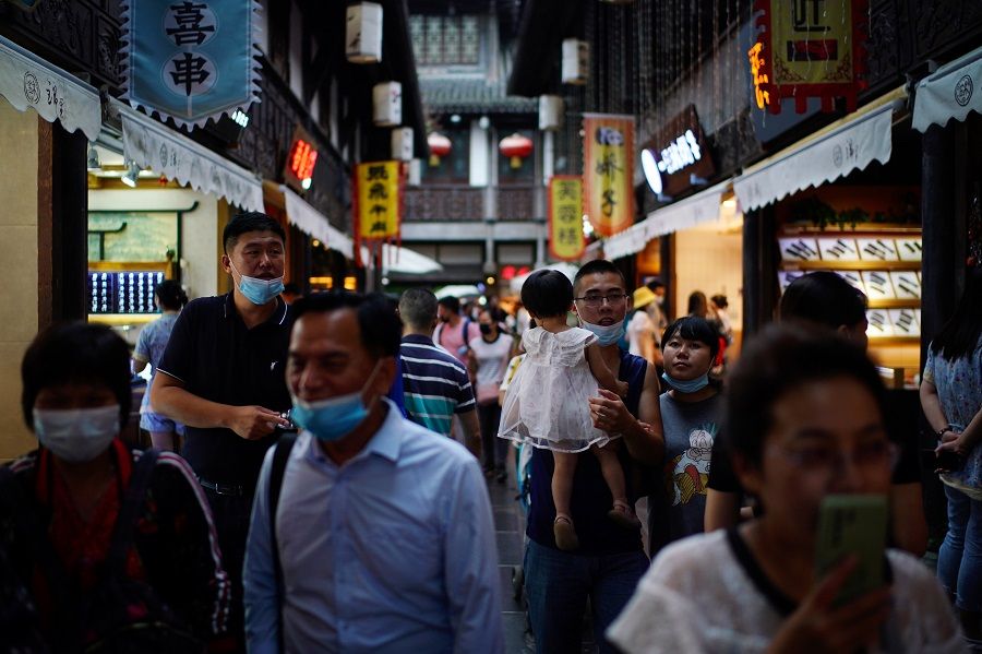 People wearing face masks walk on Jinli Ancient Street, in Chengdu, Sichuan province, China, 8 September 2020. (Tingshu Wang/Reuters)