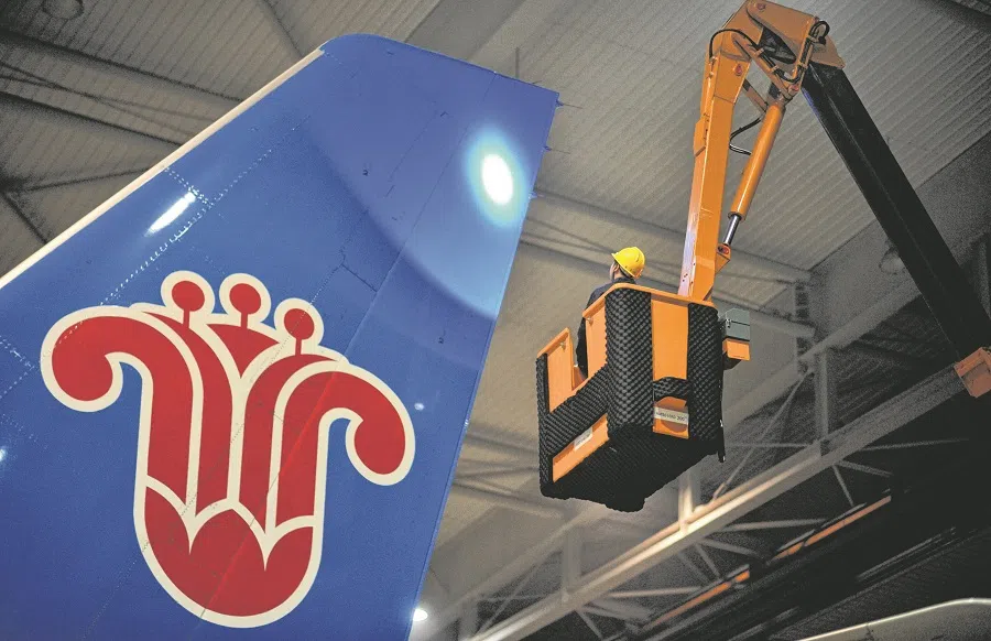 An employee of China Southern Airlines checks a plane at a maintenance base in Haikou, Hainan province, China, on 28 January 2018. (Stringer/Reuters)