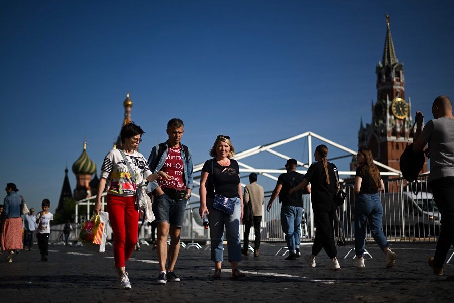 People stroll on Red Square in front of the Spasskaya Tower and St. Basil's Cathedral in downtown Moscow, Russia, on 7 June 2022. (Natalia Kolesnikova/AFP)