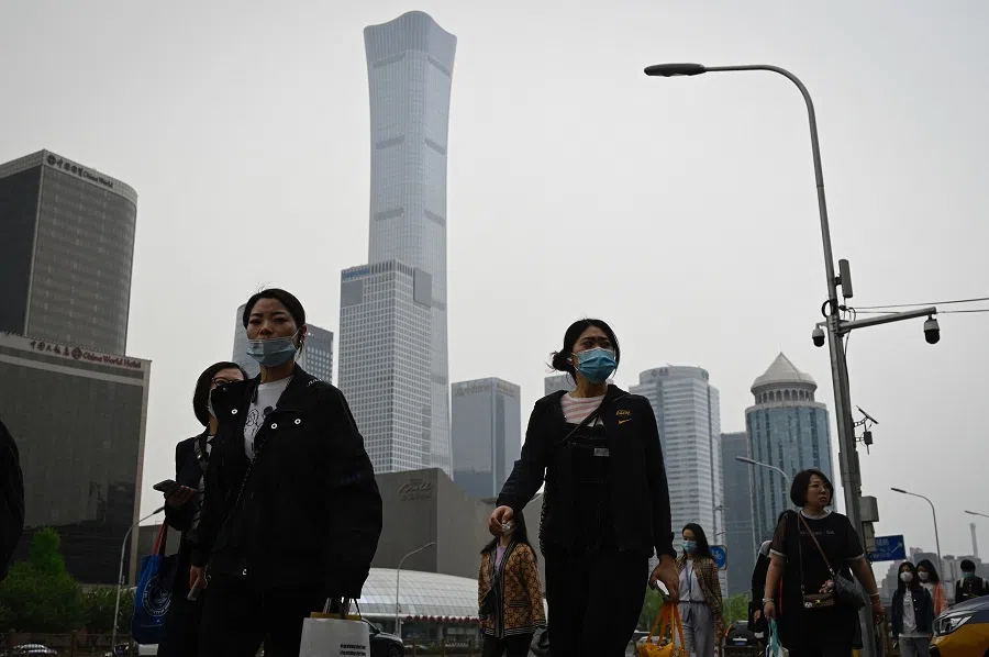 People commute at the central business district in Beijing, China, on 21 April 2022. (Jade Gao/AFP)