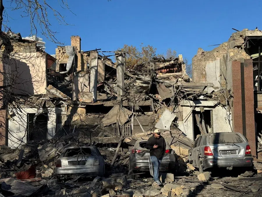 A resident walks next to buildings and cars heavily damaged by a Russian missile strike in Odesa, Ukraine, on 25 November 2024. (Ukraine’s President Volodymyr Zelenskyy via Telegram/Handout via Reuters)