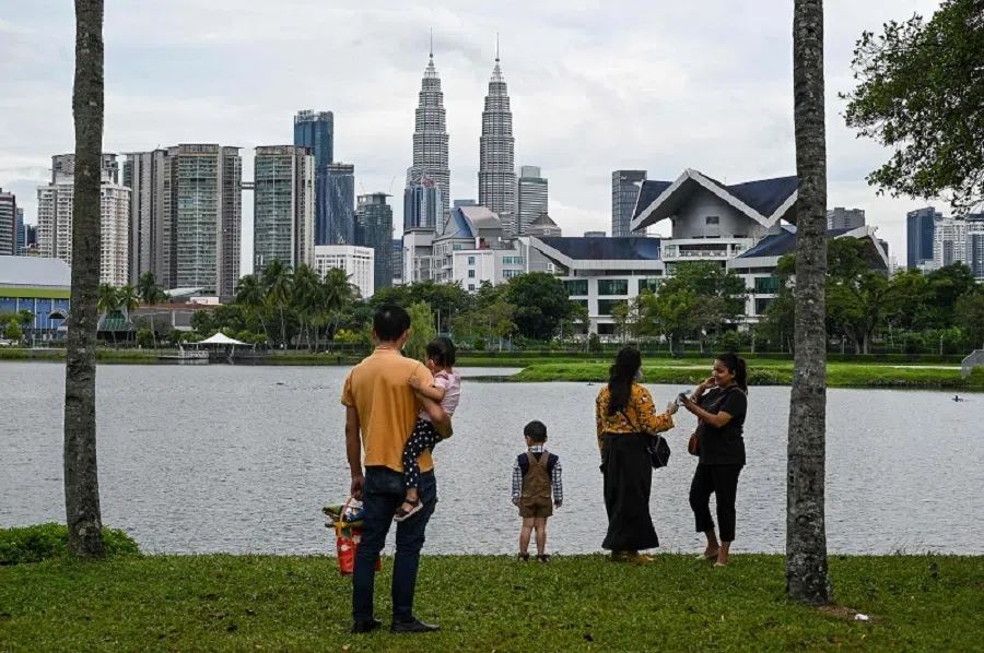 Visitors look at the city skyline from a park in Kuala Lumpur on 30 September 2021. (Mohd Rasfan/AFP)