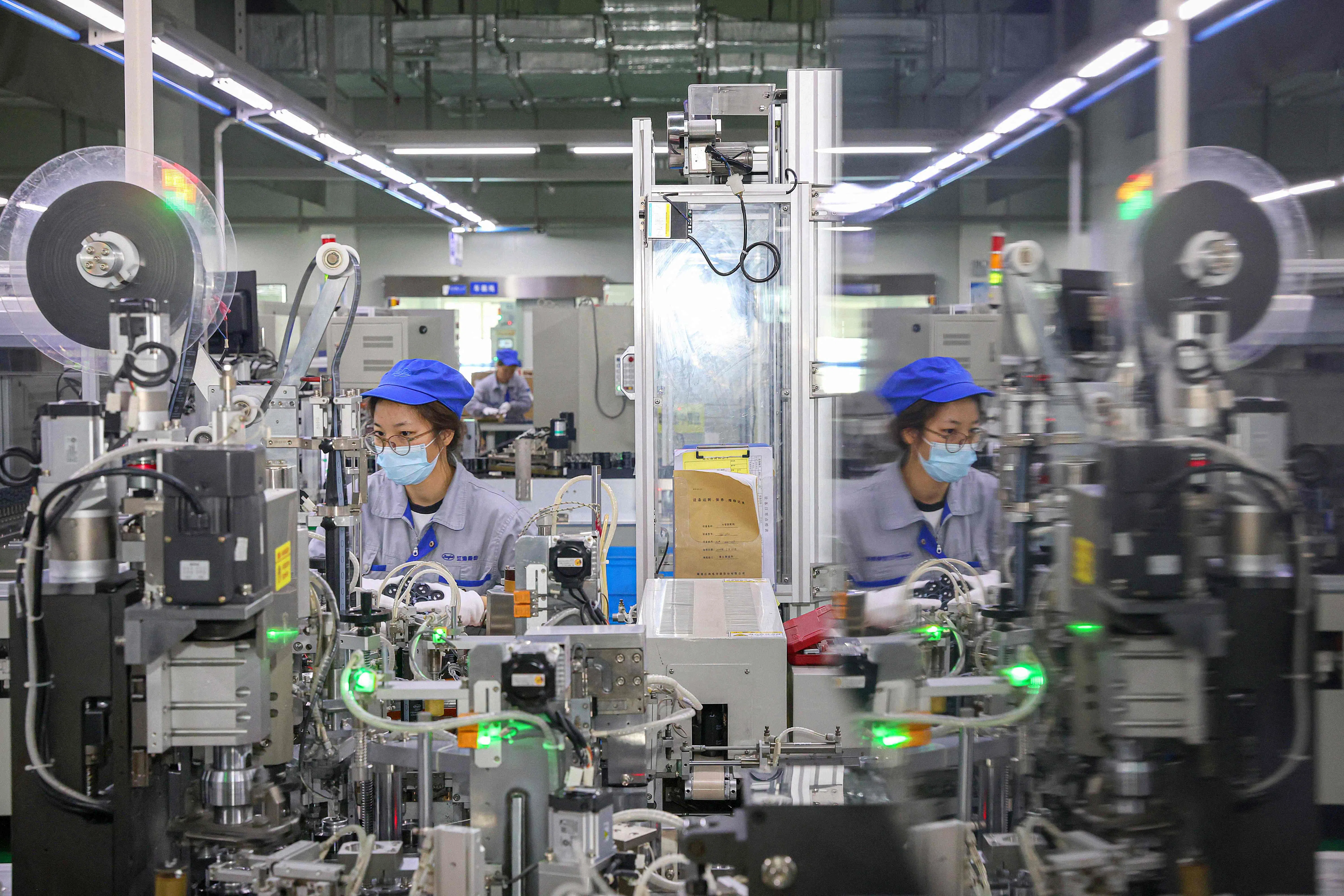 Employees produce electronic components at a factory in Nantong, in eastern China’s Jiangsu province on 6 August 2024.