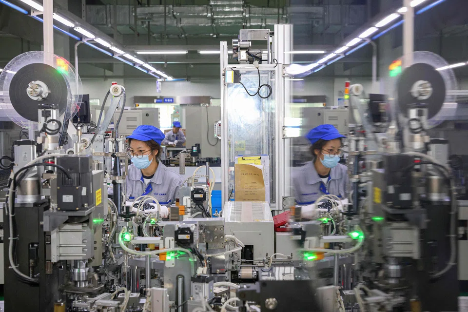 Employees produce electronic components at a factory in Nantong, in eastern China’s Jiangsu province on 6 August 2024. (AFP)