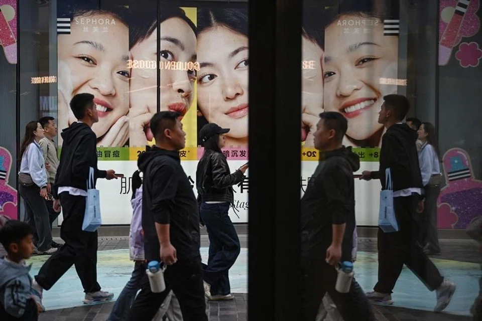 People are seen at a shopping mall in Beijing on 2 May 2026. (Greg Baker/AFP)