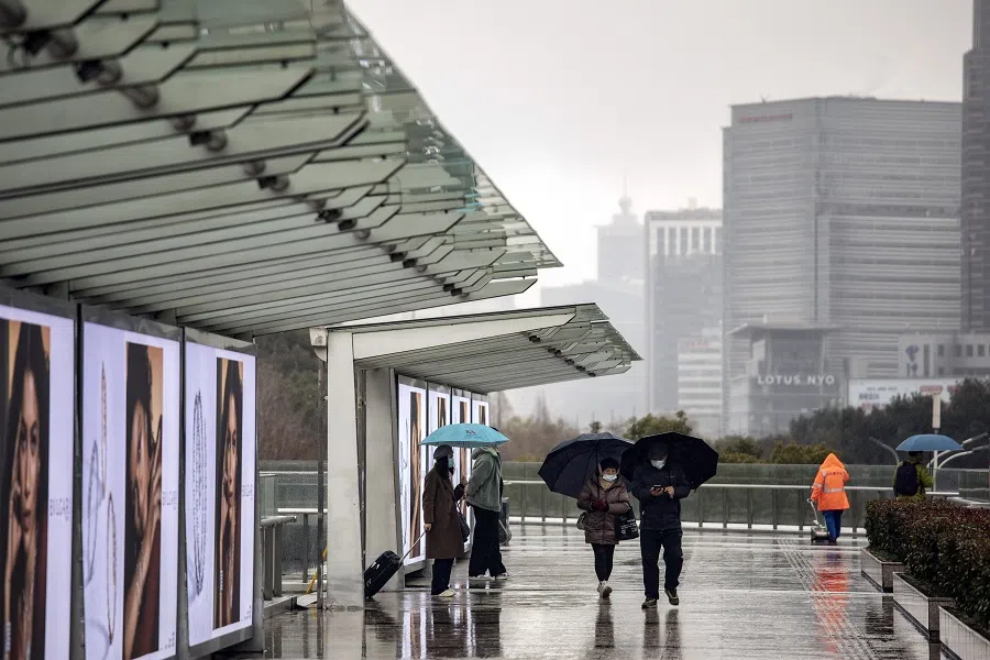 Pedestrians pass buildings in Pudong's Lujiazui Financial District in Shanghai, China, on 7 February 2022. (Qilai Shen/Bloomberg)