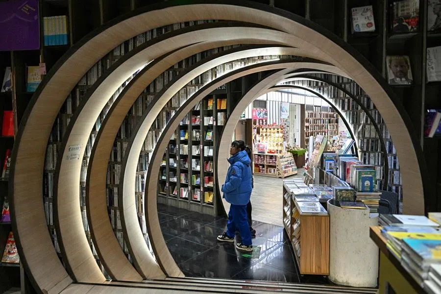 This picture taken on 19 December 2025 shows people visiting a bookstore in Beijing. (Adek Berry/AFP)