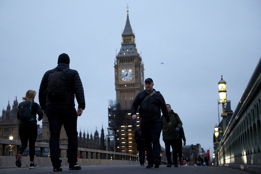 People walk over Westminster Bridge during morning rush hour in London, UK, 27 January 2022. (John Sibley/Reuters)