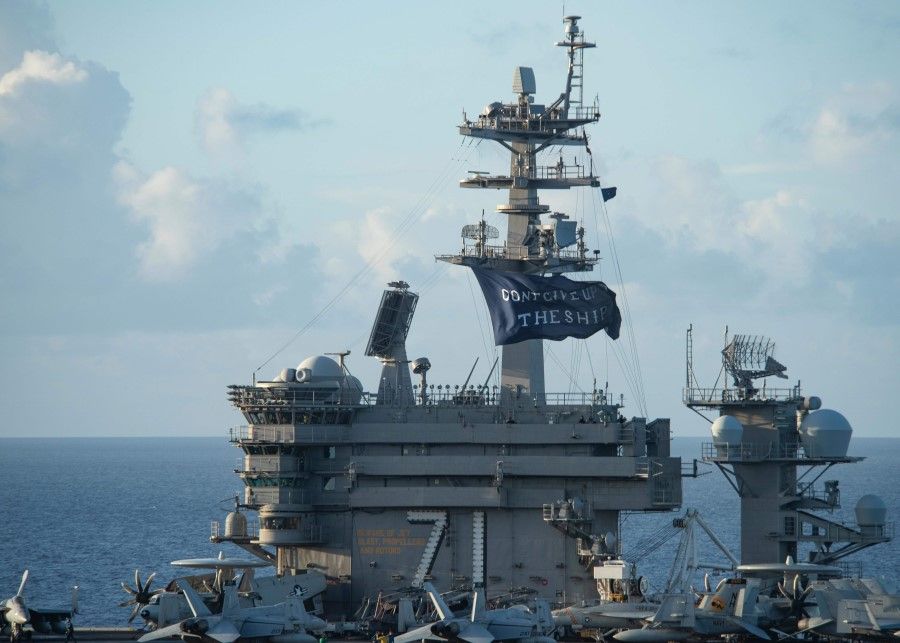 This US Navy photo shows the aircraft carrier USS Theodore Roosevelt (CVN 71) as it flies a replica of Capt. Oliver Hazard Perry's "Don't Give Up the Ship" flag, 3 June 2020 in the Philippine Sea. (Will BENNETT / Navy Office of Information / AFP)