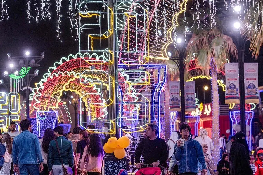 People walk at the Sheikh Zayed Heritage Festival as they await the New Year’s Eve fireworks and drone show in Abu Dhabi on 31 December 2024. (Ryan Lim/AFP)