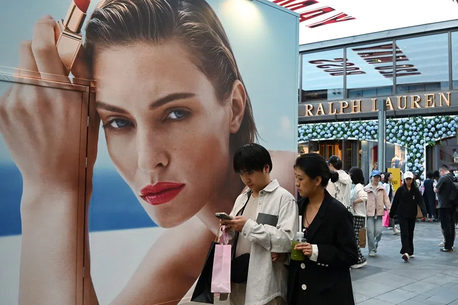 People walk through a shopping mall in Beijing, China, on 2 May 2025. (Greg Baker/AFP)
