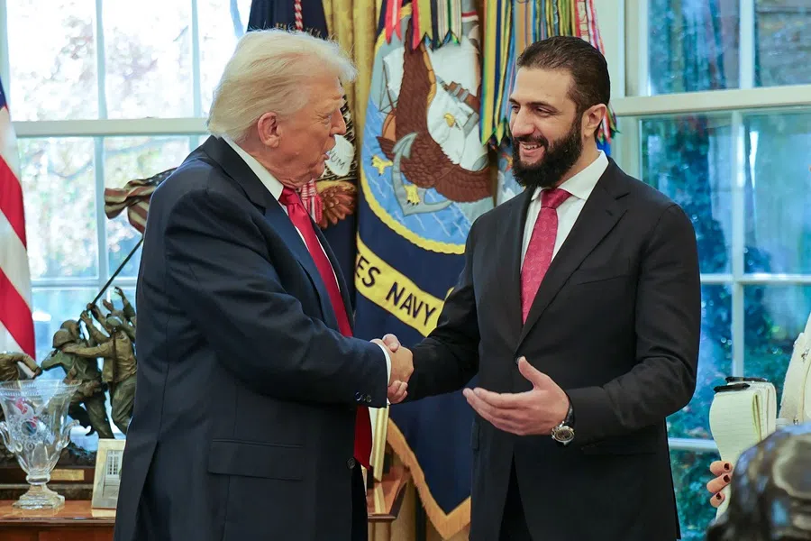 This handout photograph released by the official Syrian Arab News Agency (SANA) on 10 November 2025, shows US President Donald Trump (L) shaking hands with Syria's President Ahmed al-Sharaa at the White House in Washington DC.