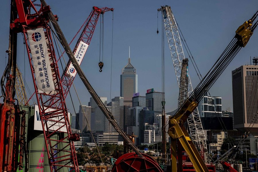 Office buildings are pictured through construction cranes in Hong Kong, China, on 28 October 2022. (Isaac Lawrence/AFP)