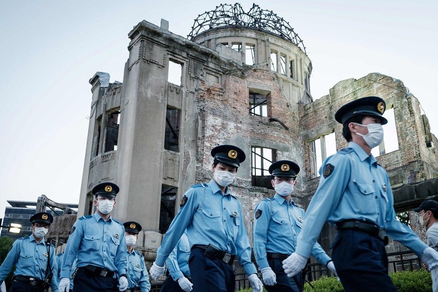 In this photo taken on 6 August 2021, police officers walk beside the Hiroshima Prefectural Industrial Promotion Hall, as it was known before 1945 and now called the Atomic Bomb Dome, as the city marks the 76th anniversary of the world's first atomic bomb attack. (Yasuyoshi Chiba/AFP)