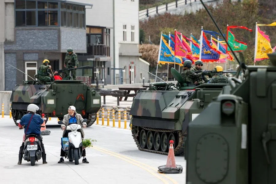 Two people on motorbikes stop to chat as military tanks are parked on the roadside on Beigan Island, Matsu archipelago, Taiwan, on 16 March 2026. (Ann Wang/Reuters)