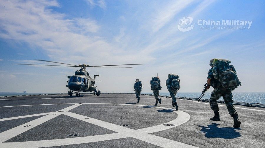 PLA soldiers run to board a transport helicopter on the flight deck of the dock landing ship Yimengshan of the PLA Navy during an inter-Services maritime coordinated training exercise at an undisclosed sea area on 3 August 2020. (Li Shilong/eng.chinamil.com.cn)