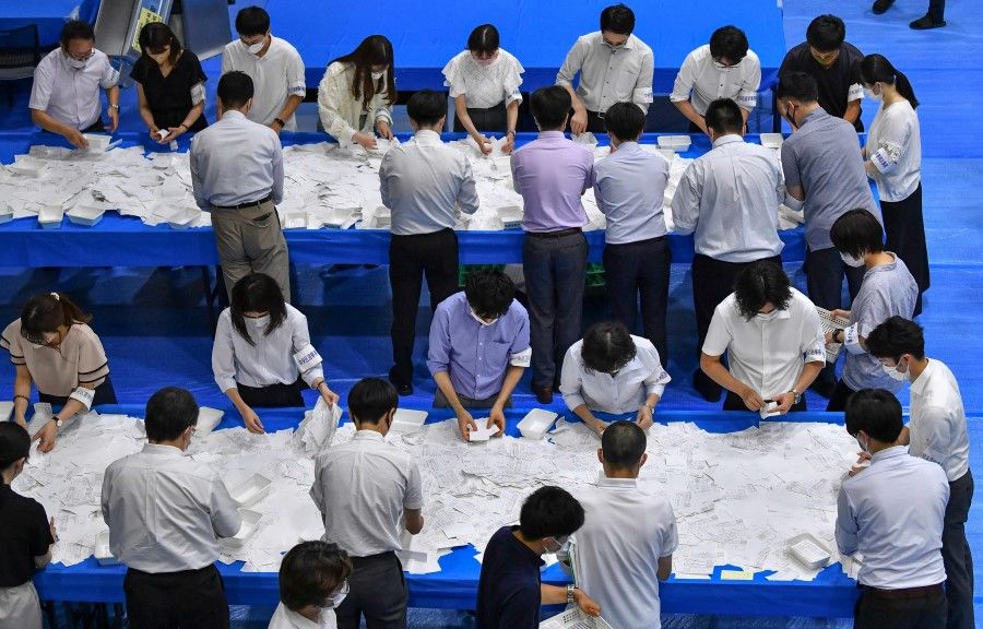 Officials of the election administration committee count the votes for Japan's upper house election in Tokyo on 10 July 2022. (Kazuhiro Nogi/AFP)