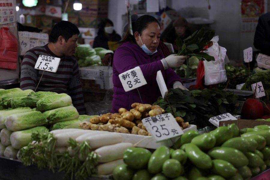 A vendor sorts vegetables at a market in Shenyang, in northeastern Liaoning province on 9 December 2020. (STR/AFP)