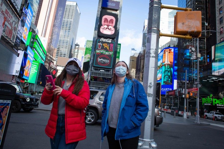 People wear face masks as they visit Times Square in New York on 10 December 10, 2020. (Kena Betancur/AFP)