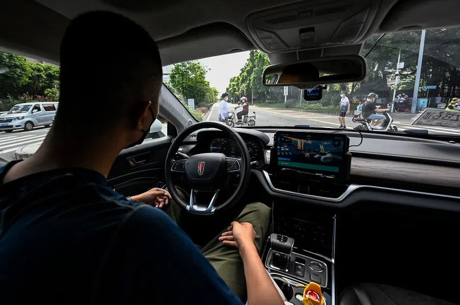 This photo taken on July 10, 2022 shows a “robotaxi” autonomous vehicle developed by Baidu Apollo stopping as people cross a street in Shenzhen, in Chinas southern Guangdong province. 