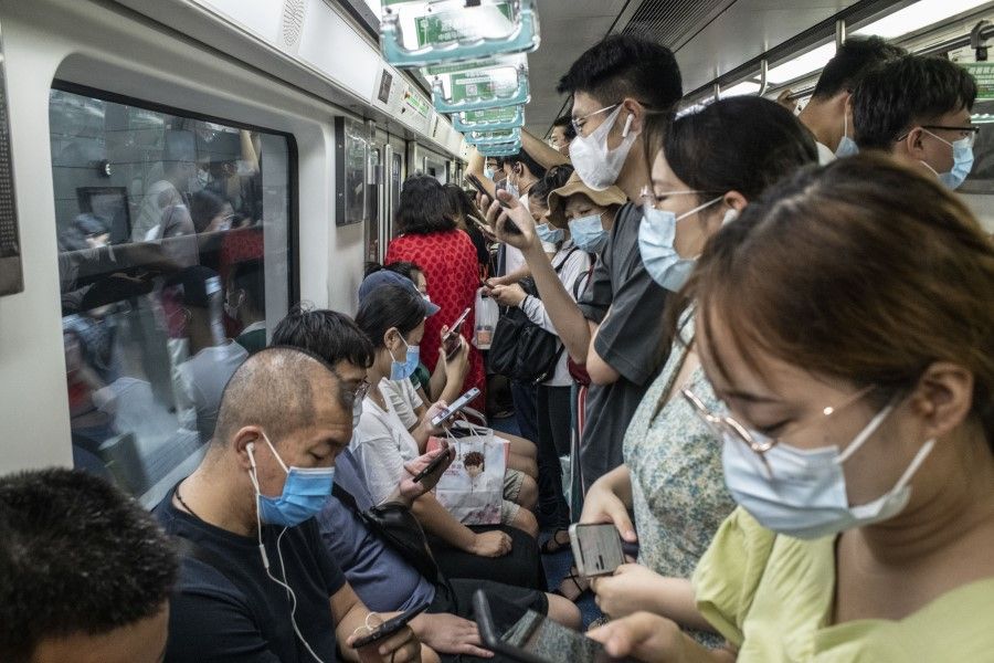 Commuters wearing protective masks ride onboard a subway train during the morning rush hour in Beijing, China, on 9 August 2021. (Gilles Sabrie/Bloomberg)