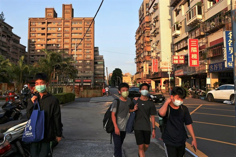 Students walk on a street during sunset hours in New Taipei City, Taiwan, 14 July 2022. (Ann Wang/Reuters)
