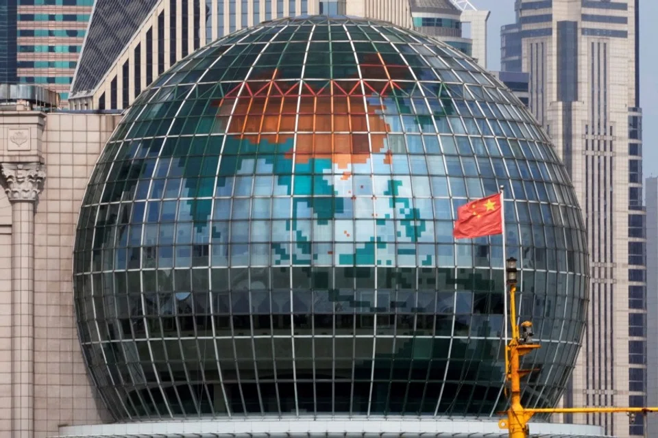 A Chinese flag flutters in front of a globe in Shanghai, China, 2 August 2022. (Aly Song/Reuters)