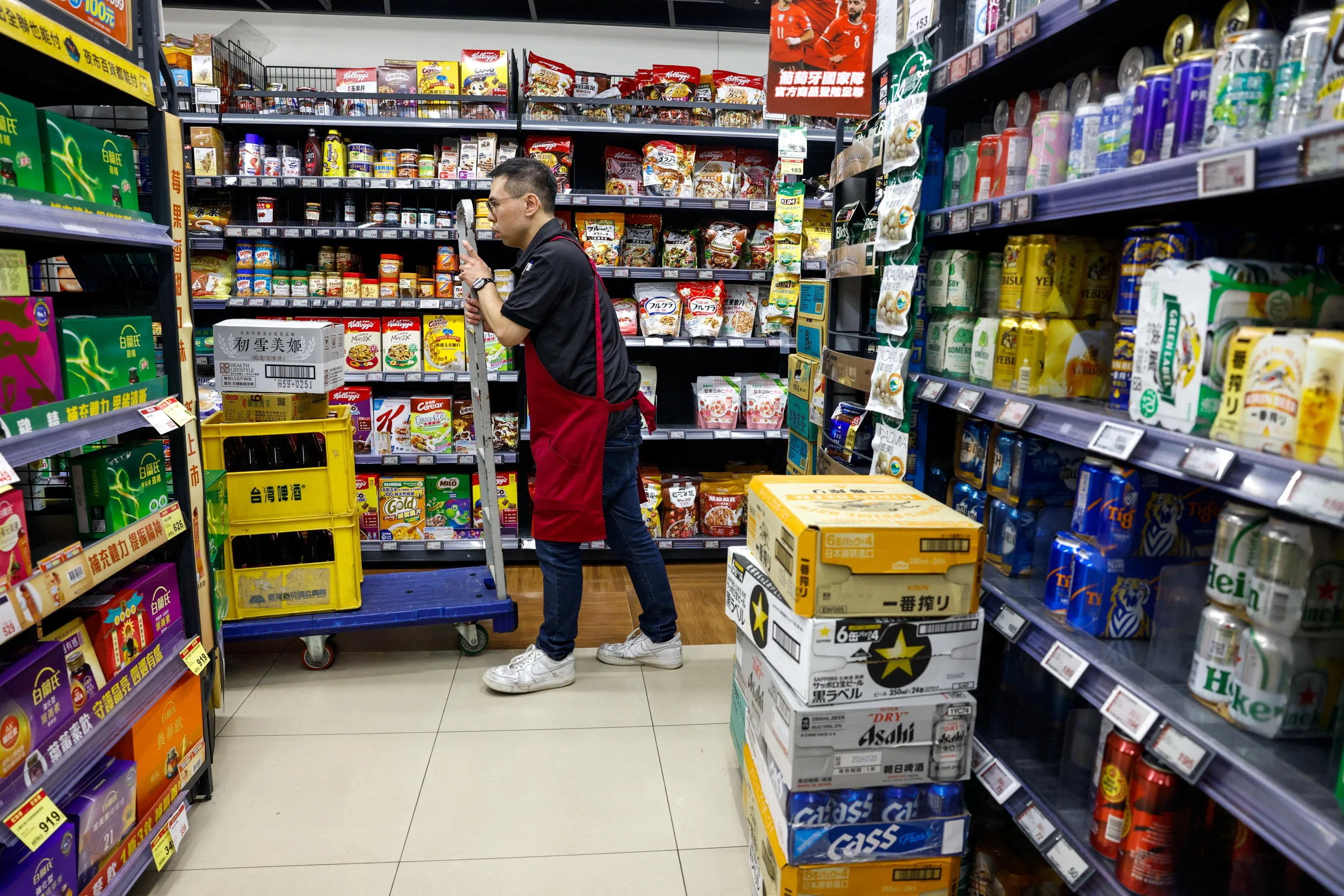 A supermarket employee restocks shelves as residents stock up on supplies ahead of the arrival of Typhoon Bavi in Taipei, Taiwan, on 9 July 2026.