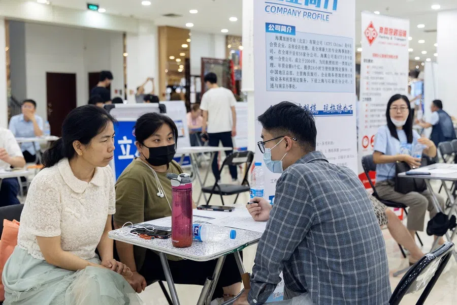 People attend a job fair in a mall in Beijing, China, on 30 June 2023. (Thomas Peter/Reuters)
