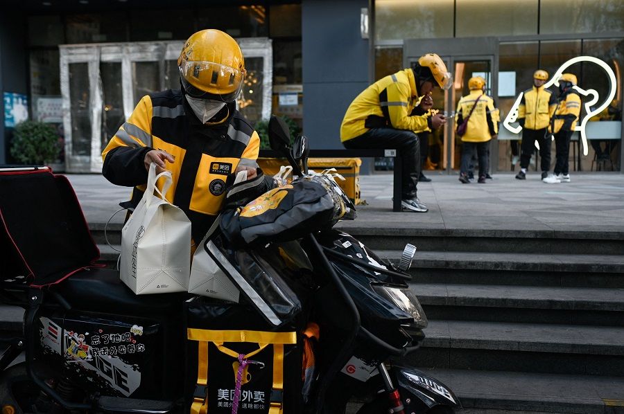 A group of delivery men of Meituan prepare to deliver food in Beijing, China, on 16 November 2023. (Wang Zhao/AFP)
