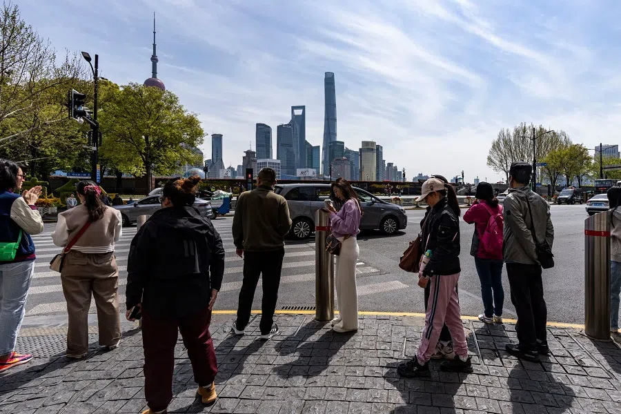 Pedestrians wait to cross a road in front of buildings in Pudong’s Lujiazui financial district in Shanghai, China, on 3 April 2025. (Qilai Shen/Bloomberg)