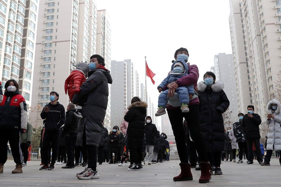 People practise social distancing as they line up for a second round of citywide nucleic acid testing at a residential compound, following new cases of the Covid-19 coronavirus in Shijiazhuang, Hebei province, China, 12 January 2021. (China Daily via Reuters)