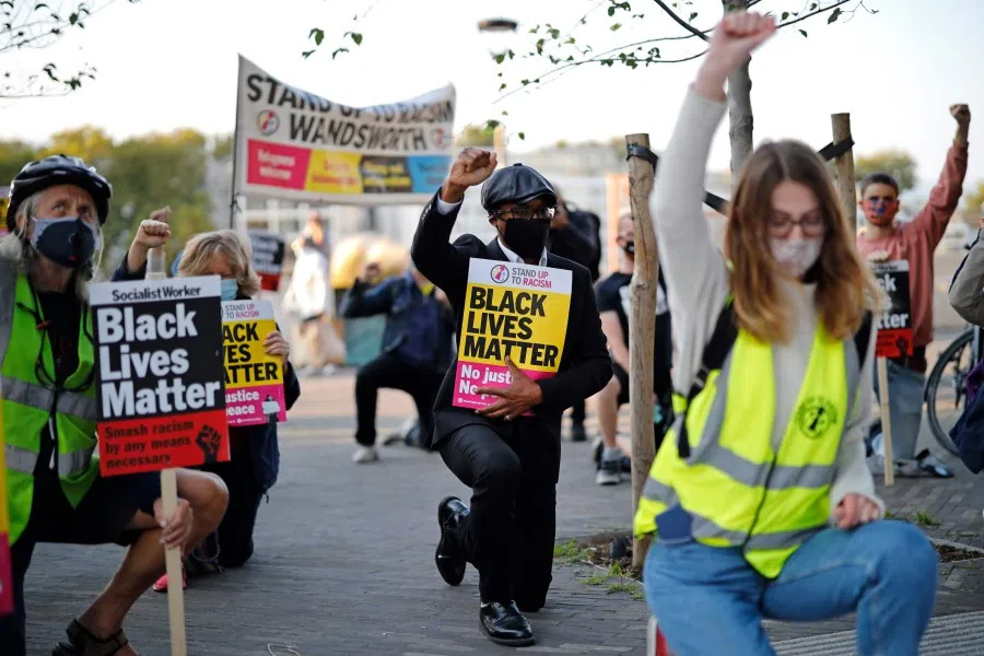 Protesters from Black Lives Matter take a knee as they gather outside the US Embassy in London on 11 September 2020, the day of a trial hearing of the four police officers charged with the murder of George Floyd in the US. (Tolga Akmen/AFP)