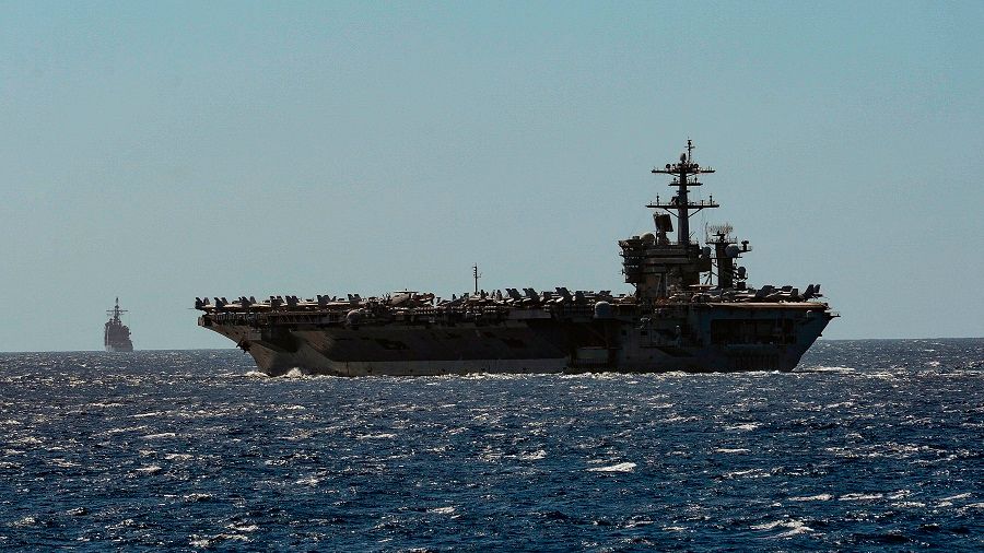 This US Navy handout photo obtained on 1 April 2020 shows the aircraft carrier USS Theodore Roosevelt and the Ticonderoga-class guided-missile cruiser USS Bunker Hill as they transit the Philippine Sea on 29 February 2020. (Sean Lynch/US Navy/Handout/AFP)