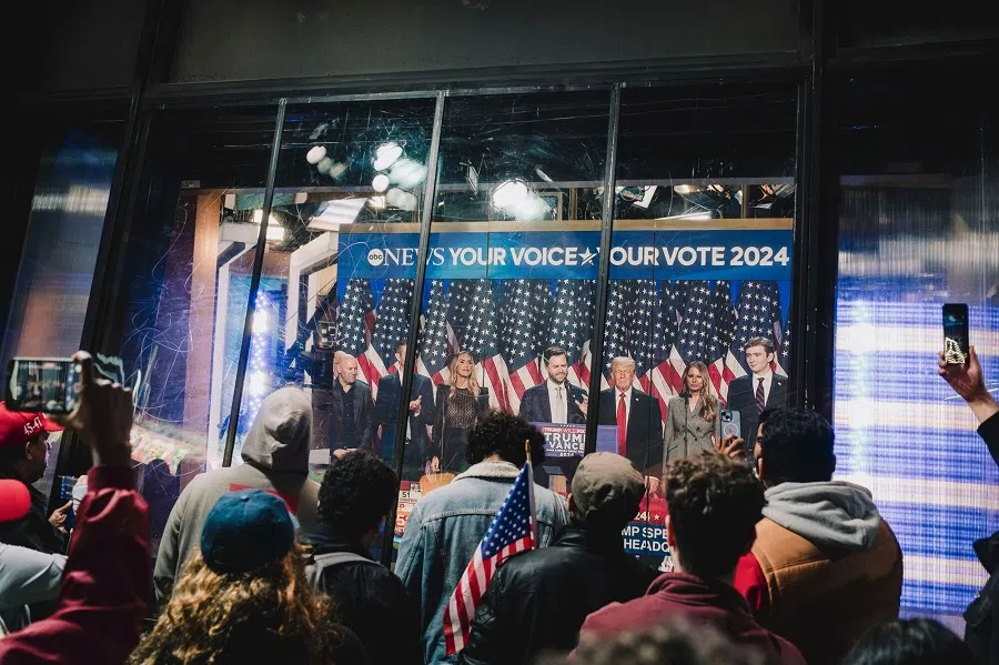 Onlookers watch a broadcast of US President-elect Donald Trump addressing his election night watch party, in Times Square in New York, US, on 6 November 2024. (Mark Abramson/Bloomberg)