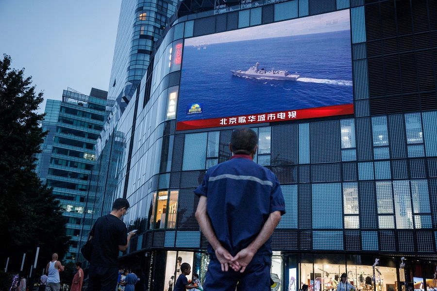 A man watches a CCTV news broadcast about joint military operations near Taiwan by the Chinese People's Liberation Army (PLA) Eastern Theater Command, at a shopping centre in Beijing, China, 3 August 2022. (Thomas Peter/Reuters)